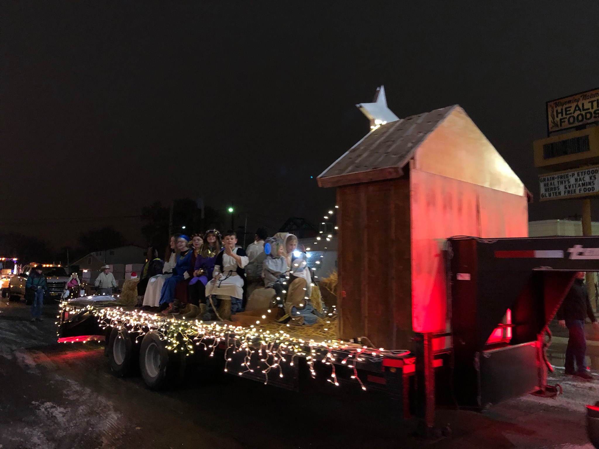 Photo of Lighted Parade. Kids sitting on a trailer decorated as the manger.