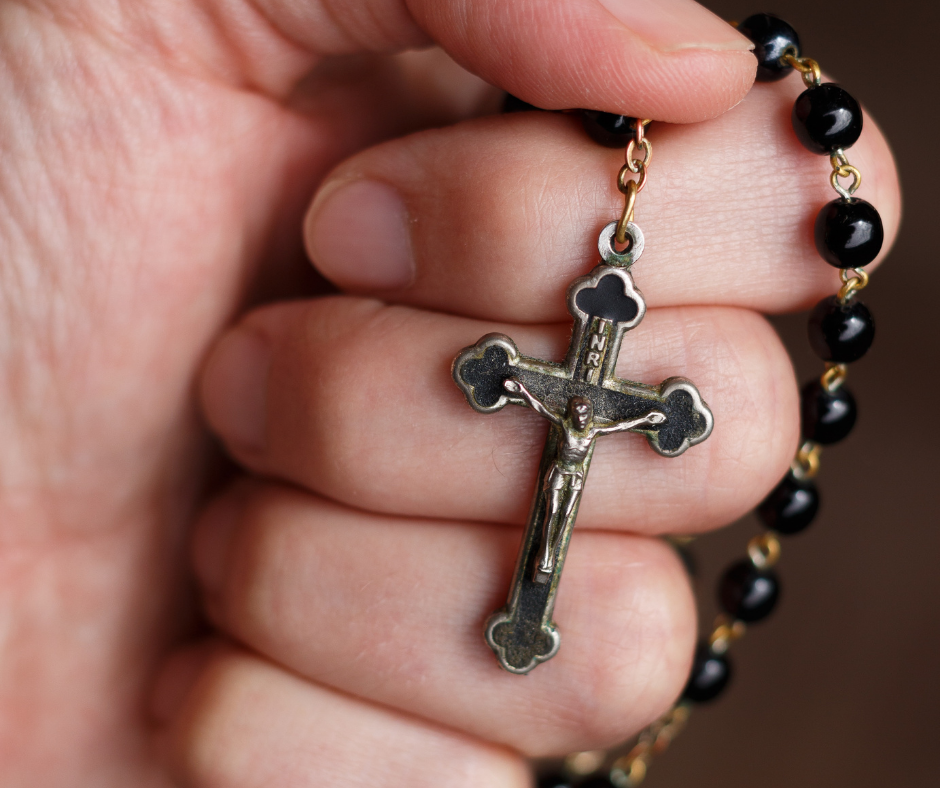 Hand gripping rosary - Churches in Powell