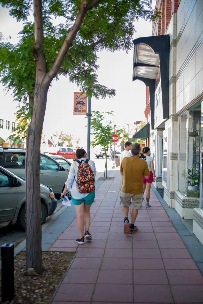 A group of people walking down the vibrant streets of downtown Powell, Wyoming in the summertime