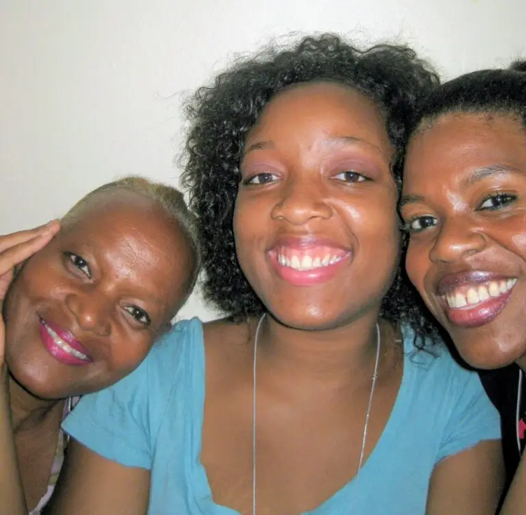 A photo of three women posing closely together, featuring Renee Robinson in the middle, an AmeriCorps VISTA Alumni who served in the Powell, Wyoming area