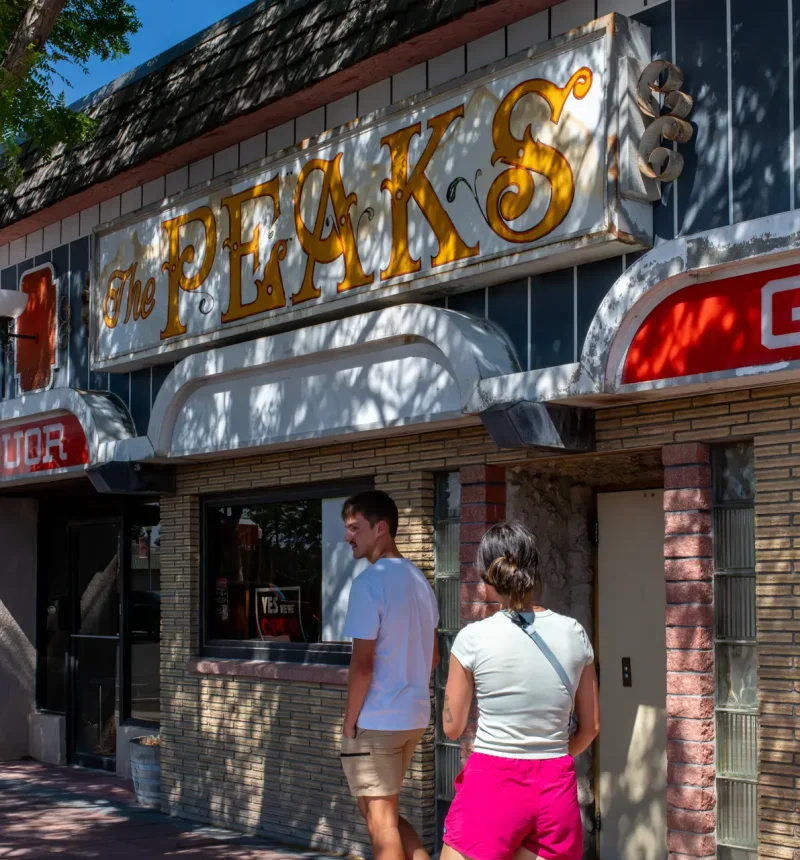 A young couple exploring downtown Powell, Wyoming in front of The McCullough Peaks Bar