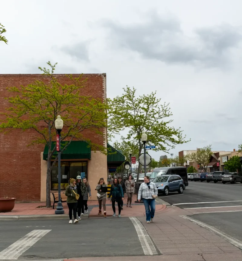 A group of people walking and touring in downtown Powell, Wyoming during the fall